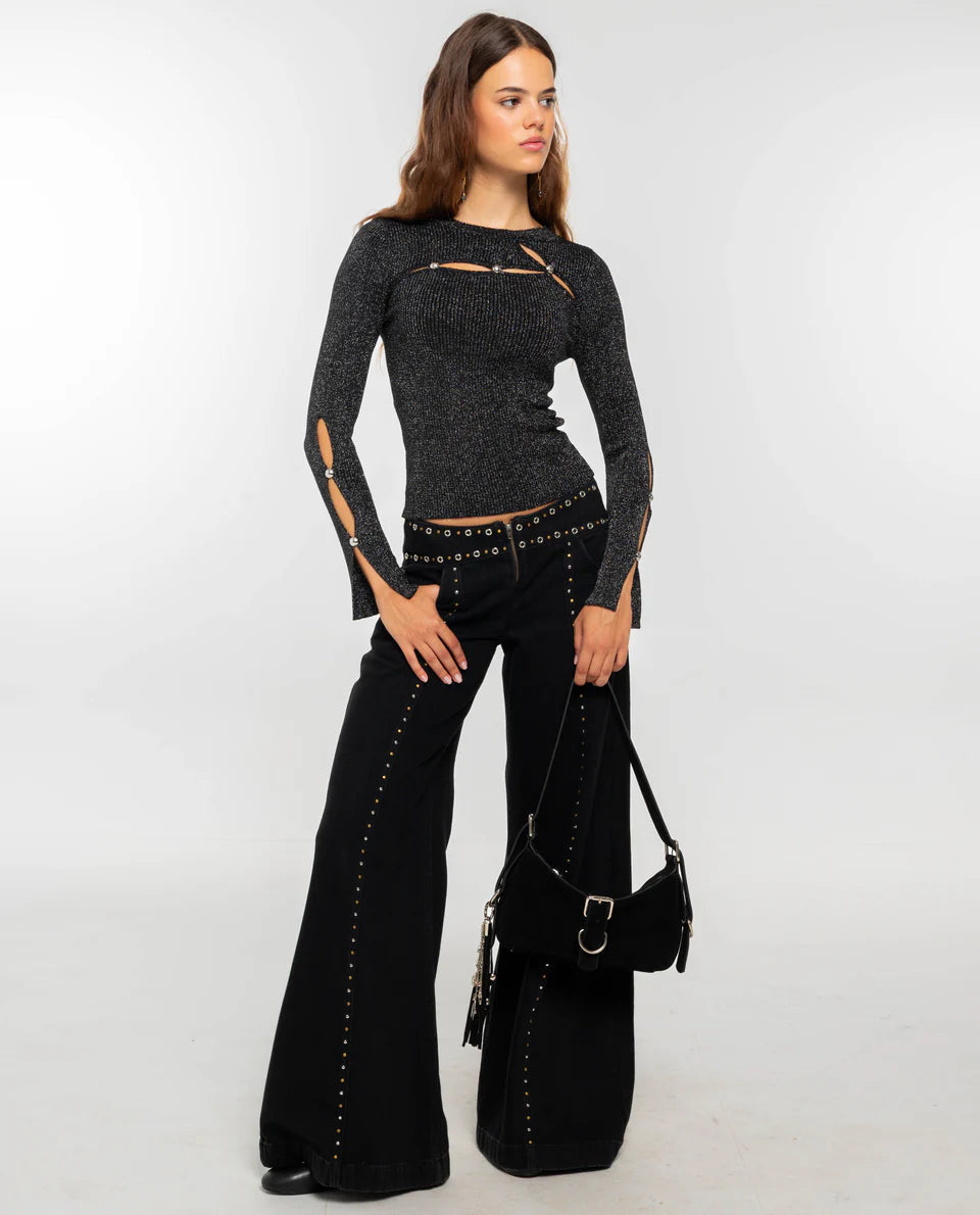 Women's dark burgundy ribbed knit long-sleeve top featuring cut-out details across the chest and forearms, held together by round metallic hardware.