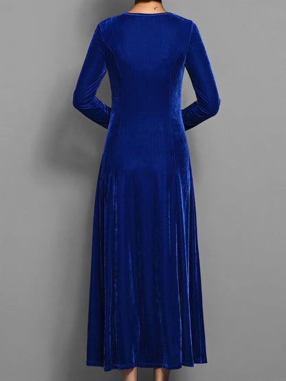Blue - A woman wearing a long sleeve, A-line velvet maxi dress with vertical panelled seams.