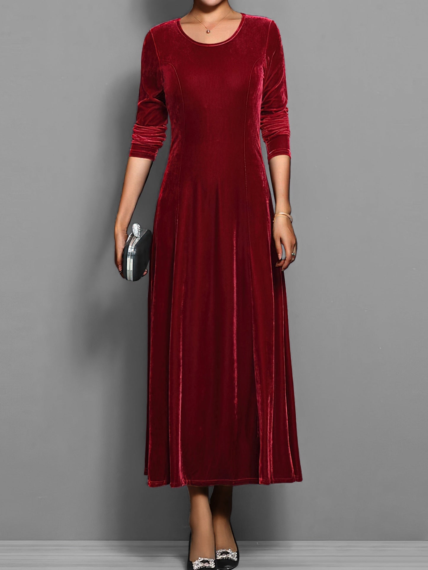 Red - A woman wearing a long sleeve, A-line velvet maxi dress with vertical panelled seams.