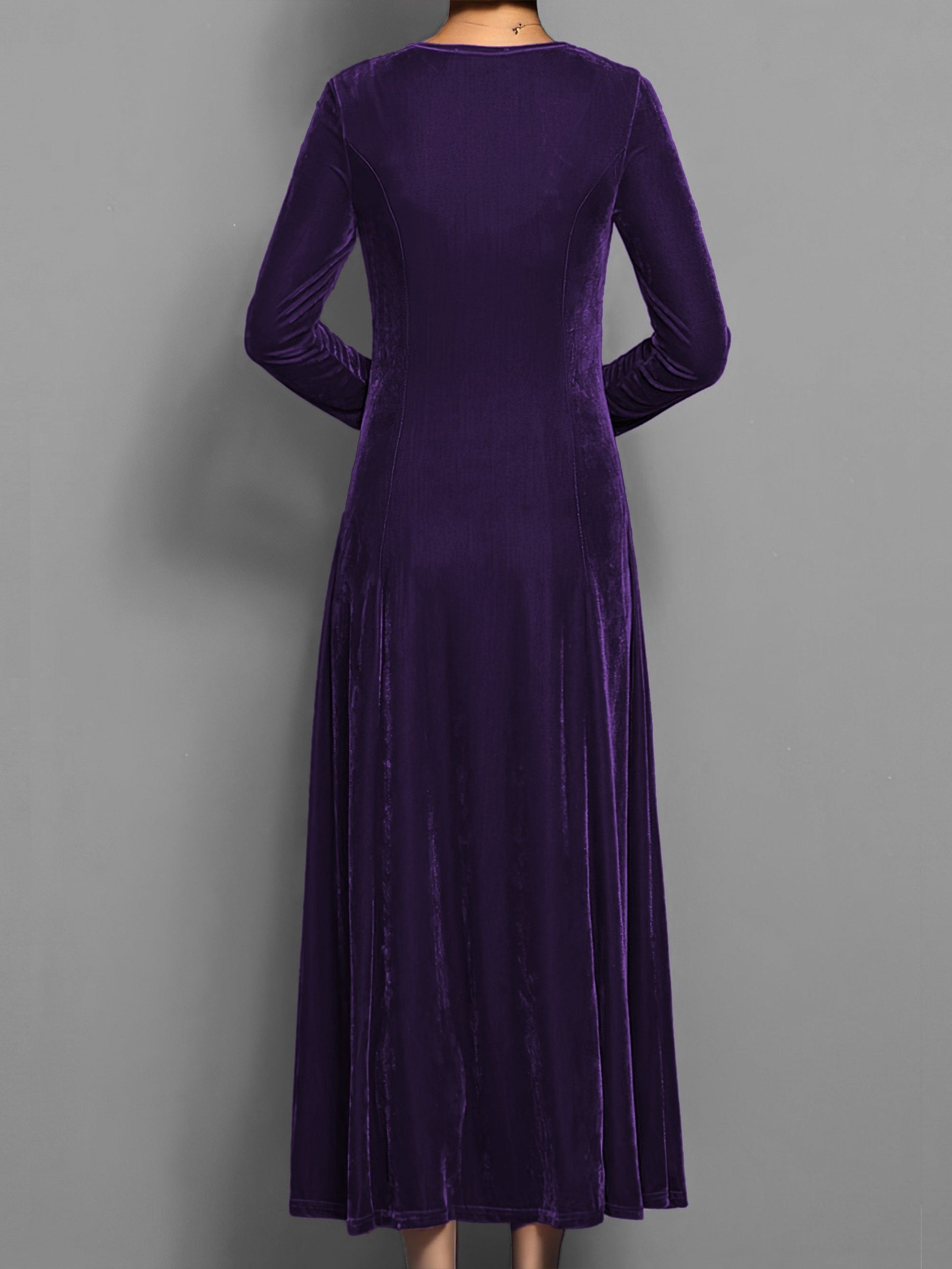 Purple - A woman wearing a long sleeve, A-line velvet maxi dress with vertical panelled seams.