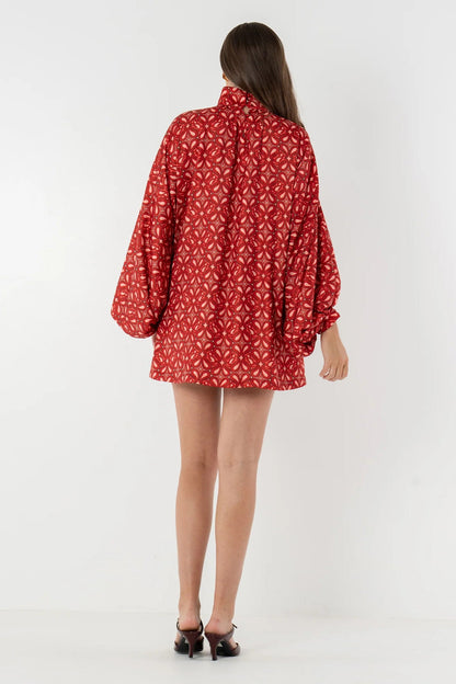 Model wearing a patterned woven mini dress featuring a high neckline, voluminous balloon sleeves, and a relaxed shift silhouette, styled with western boots and holding an acoustic guitar