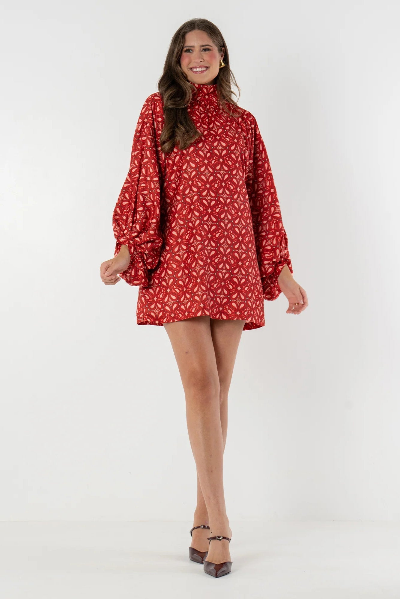 Red - Model wearing a patterned woven mini dress featuring a high neckline, voluminous balloon sleeves, and a relaxed shift silhouette, styled with western boots and holding an acoustic guitar