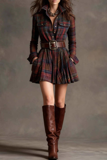 Model wearing a woven plaid long-sleeve mini shirtdress with a pleated skirt, styled with a wide statement belt and knee-high leather boots.